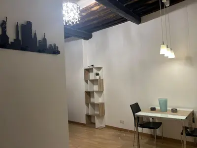a dining room with a table and chairs and a chandelier at Loft Trastevere in Rome