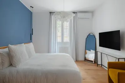 a bedroom with a white bed and a television at Cereate Suites in Rome