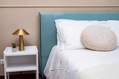 a bed with a pillow and a lamp on a night stand at Domina Apartments Roma - San Pietro 3 in Rome