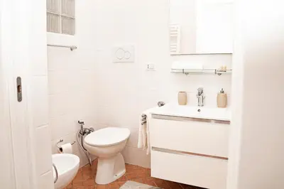 a white bathroom with a toilet and a sink at Domina Apartments Roma - San Pietro 3 in Rome