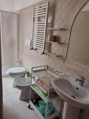 a bathroom with two toilets and a sink and a mirror at Mary Apartment in Rome