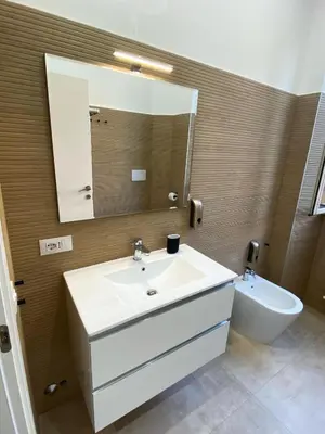 a bathroom with a sink and a mirror and a toilet at Domus Quadraro II in Rome