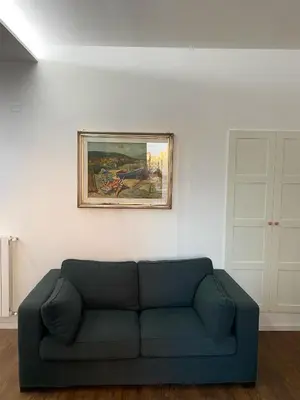 a couch in a living room with a painting on the wall at Domus Quadraro II in Rome