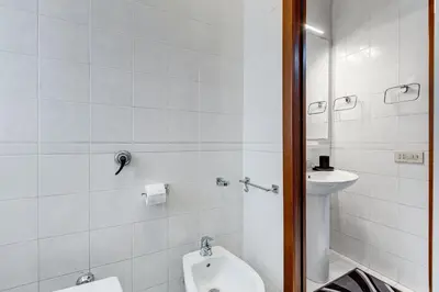 a white bathroom with a toilet and a sink at Cozy 2-Bedroom Flat with Balcony in Monteverde in Rome