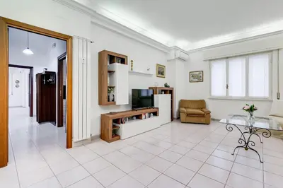 a living room with a tv and a couch and a table at Cozy 2-Bedroom Flat with Balcony in Monteverde in Rome