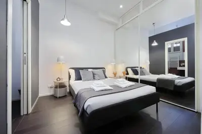 a bedroom with two beds and a mirror at Il Rifugio di Boezio by DomusDimore in Rome