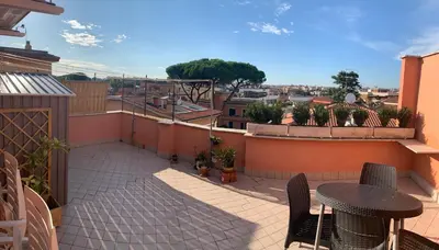 a patio with a table and chairs on a balcony at Mazzoni Suite, Panoramic Terrace and Comfort in Rome