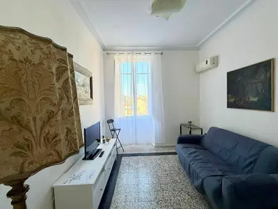 a living room with a blue couch and a window at Piramide Cestia Apartment in Rome
