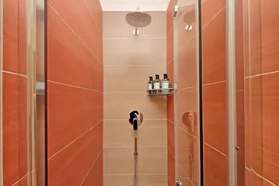 a bathroom with a shower with a glass door at Graceful Apartment near St Peter METRO 100 mt in Rome