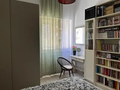 a room with a chair and a desk and a book shelf at Nido rinnovato in Rome
