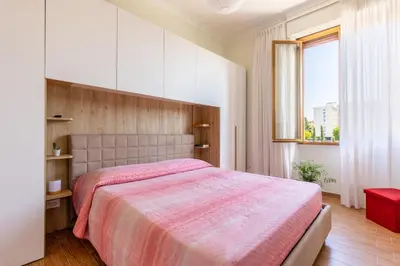 a bedroom with a large bed with a pink blanket at Cozy and Bright Pyramid Apartment in Rome