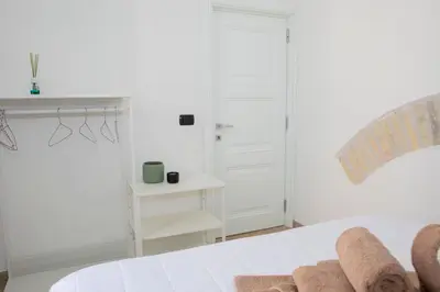 a white bedroom with a bed and a white door at Casa Carmine in Trastevere in Rome