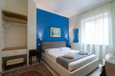 a bedroom with blue walls and a bed with towels on it at Vatican City Historic Center -Luxury Flat with Garden and Private Parking in Rome