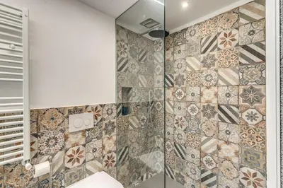 a bathroom with a shower with a tiled wall at La Casa Dei Sogni in Rome