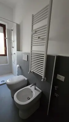 a white bathroom with a toilet and a sink at Ferrari House in Rome