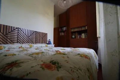 a bedroom with a bed with a floral bedspread at Domus Roma G&R in Rome