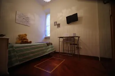 a teddy bear sitting on a bed in a room at Domus Roma G&R in Rome