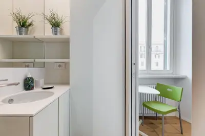 a bathroom with a sink and a green chair at Modern flat in Vatican in Rome