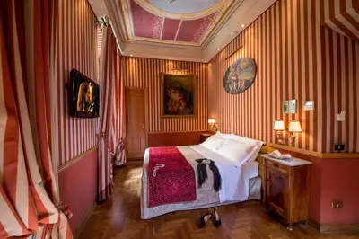 a bedroom with a bed in a room with red walls at The Inn at the Spanish Steps Elegant Collection - GioielloJewel in Rome