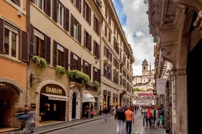 a group of people walking down a street with buildings at The Inn at the Spanish Steps Elegant Collection - GioielloJewel in Rome