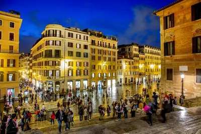 a group of people walking around a street at night at The Inn at the Spanish Steps Elegant Collection - GioielloJewel in Rome