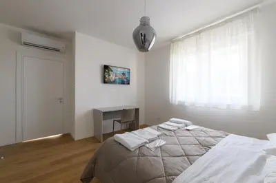 a white bedroom with a bed and a desk at Alloggio per uso turistico Roma Casal Bertone - Casa del Sole in Rome