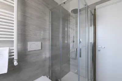 a shower with a glass door in a bathroom at Alloggio per uso turistico Roma Casal Bertone - Casa del Sole in Rome