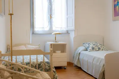 a small bedroom with two beds and a window at Amazing San Giovanni in Laterano in Rome
