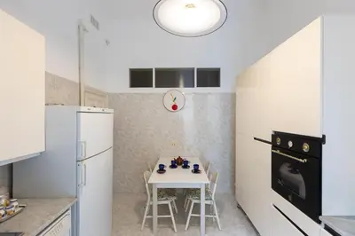 a kitchen with a white table and a white refrigerator at Amazing San Giovanni in Laterano in Rome