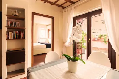 a dining room with a table and a bedroom at Principessa Trevi in Rome