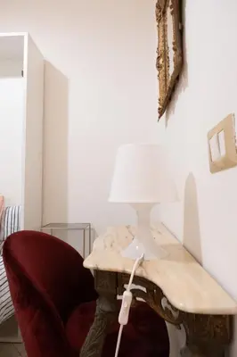 a lamp sitting on a table next to a chair at Vita Nova House 3 camere 3 bagni perfetta per famiglie e gruppi a due passi da Termini in Rome