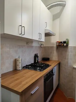a kitchen with white cabinets and a stove top oven at Saint Peters Place 2BR near Vatican in Rome