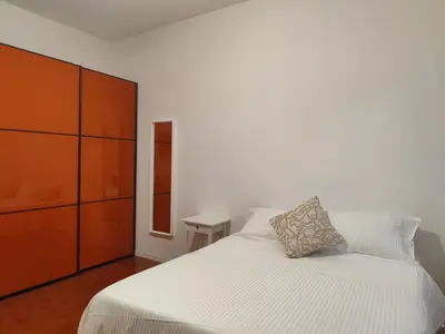 a bedroom with a white bed with a orange cabinet at Saint Peters Place 2BR near Vatican in Rome