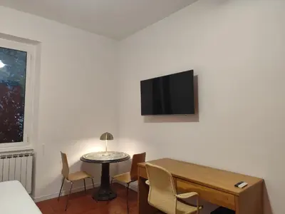 a room with a table and a tv on a wall at Saint Peters Place 2BR near Vatican in Rome