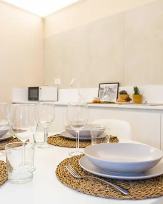 a table with wine glasses and a plate on it at Monti Nonna Francesca - ZENO 49 in Rome