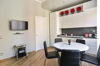 a room with a table and chairs and a kitchen at Lata Luxury Apartment in Rome