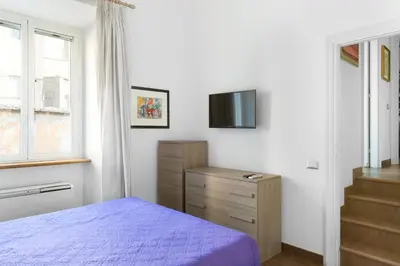 a bedroom with a bed and a tv on the wall at Casa Enriqueta in Rome