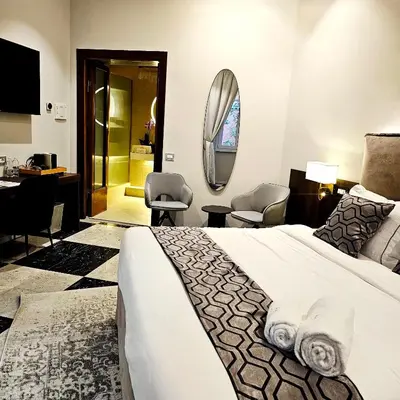 a hotel room with a large bed and a desk at STOA ROME Boutique Suites in Rome