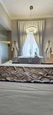 a large bathroom with a bath tub and a chandelier at STOA ROME Boutique Suites in Rome