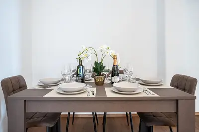 a dining room table with plates and wine bottles at Via Niso Apartment in Rome