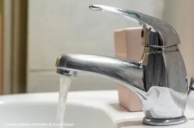 a bathroom sink with water running from a faucet at Acquedotti House in Rome