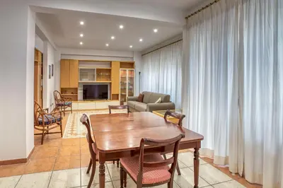 a living room with a wooden table and chairs at Dimora Savorelli, ampio appartamento zona Vaticano in Rome