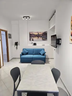 a living room with a blue couch and a table at Domus Imperiali in Rome