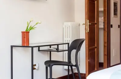 a black desk with a black chair and a vase of flowers at Torripa Group - Prati in Rome