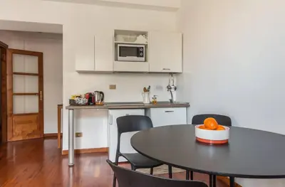 a kitchen with a table and chairs and a microwave at Torripa Group - Prati in Rome