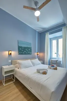 a blue bedroom with a large bed with two towels on it at Vatican Lante Apartment in Rome