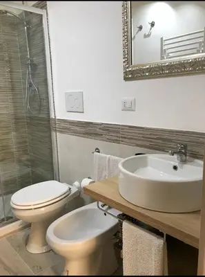 a bathroom with a toilet and a sink and a mirror at Suite Old Testaccio 2 in Rome