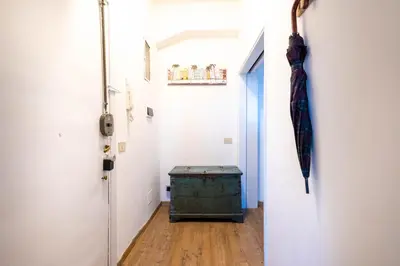 a hallway with an open door and an old trunk at Urban Trastevere Rome apartment Ripa 11 in Rome