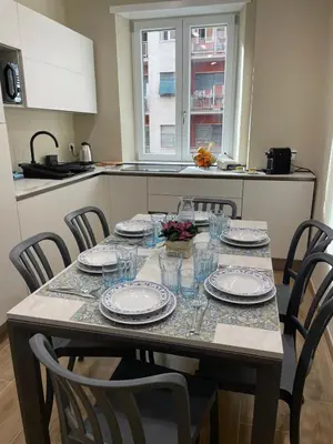 a table with plates and glasses on it in a kitchen at SAINT PETER home and holiday apartment in Rome