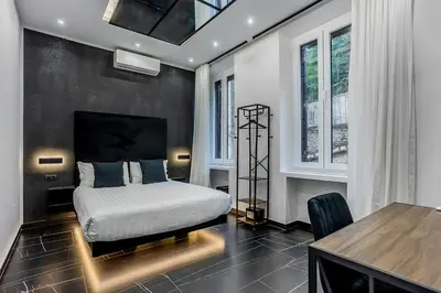 a bedroom with a bed and a table and windows at Medaglie d'Oro Vaticano in Rome